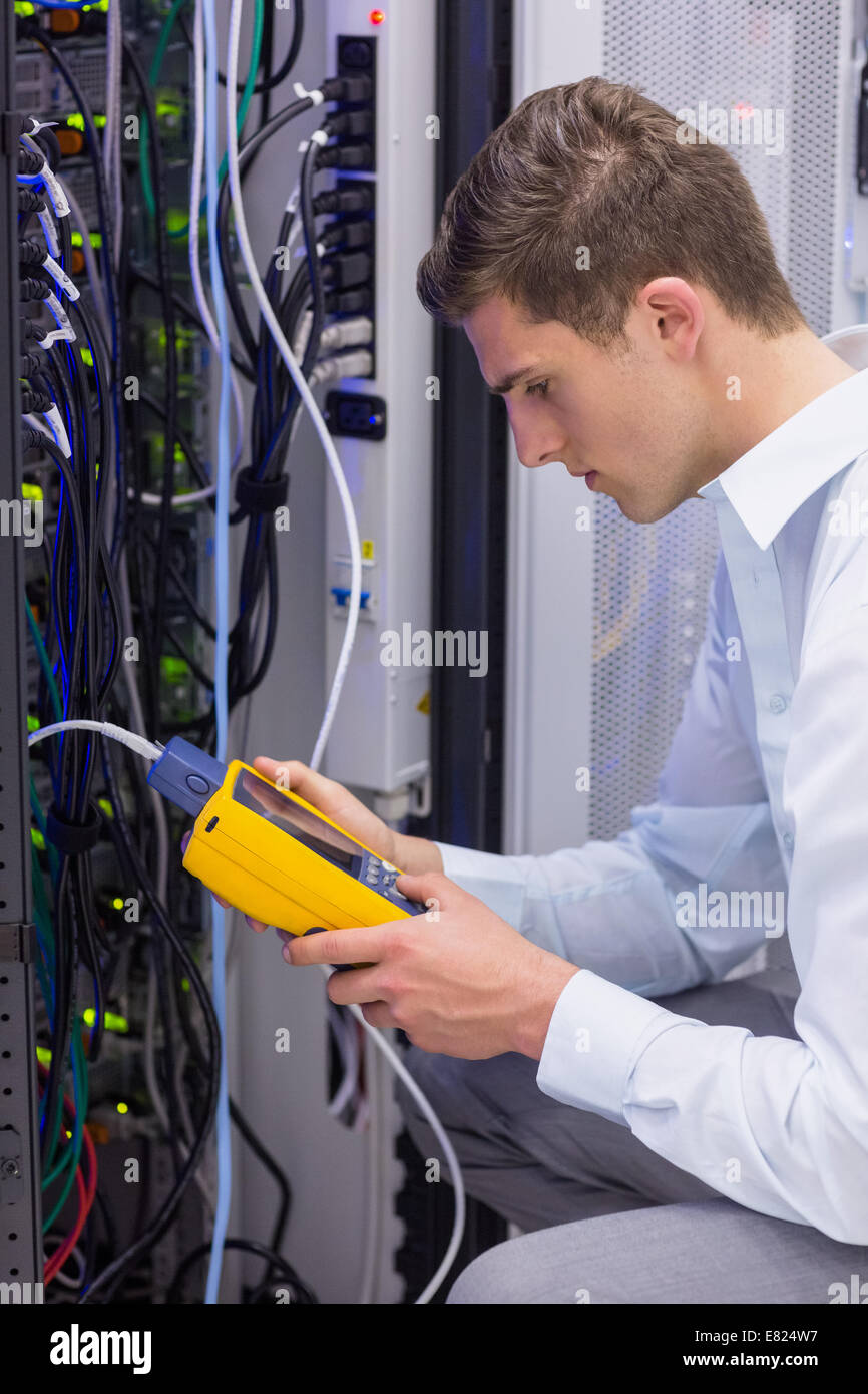 Serious technician using digital cable analyzer on server Stock Photo ...
