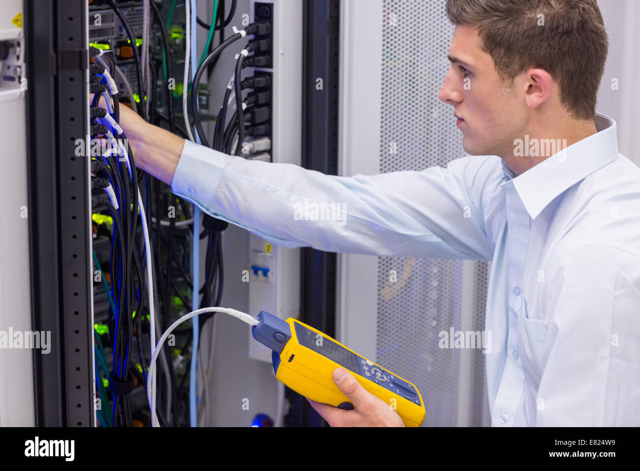 Serious technician using digital cable analyzer on server Stock Photo ...