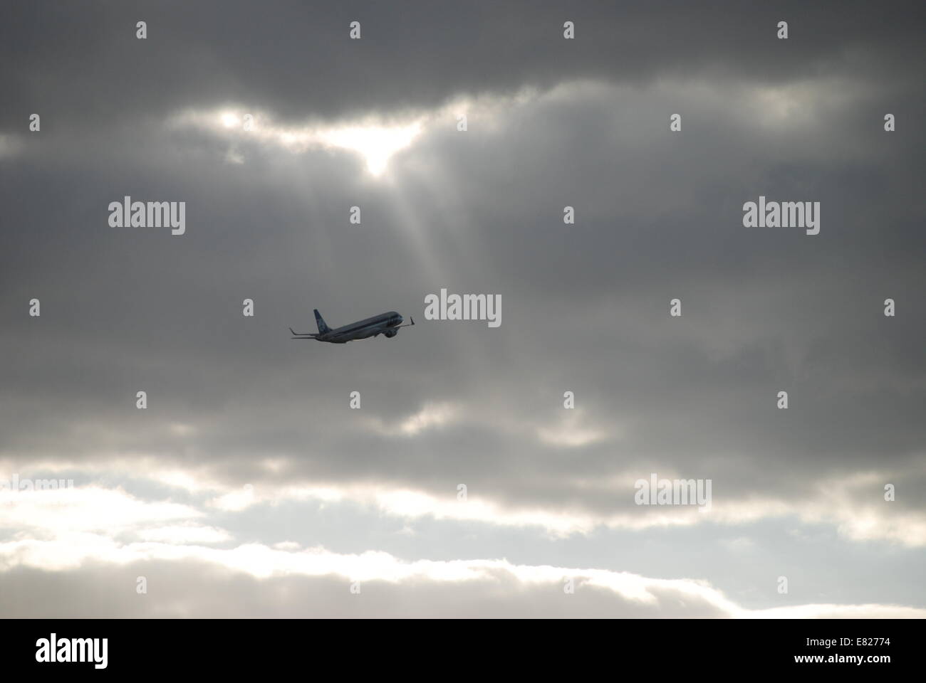 Sun rays breaking through clouds above plane Chopin Airport Warsaw. Stock Photo