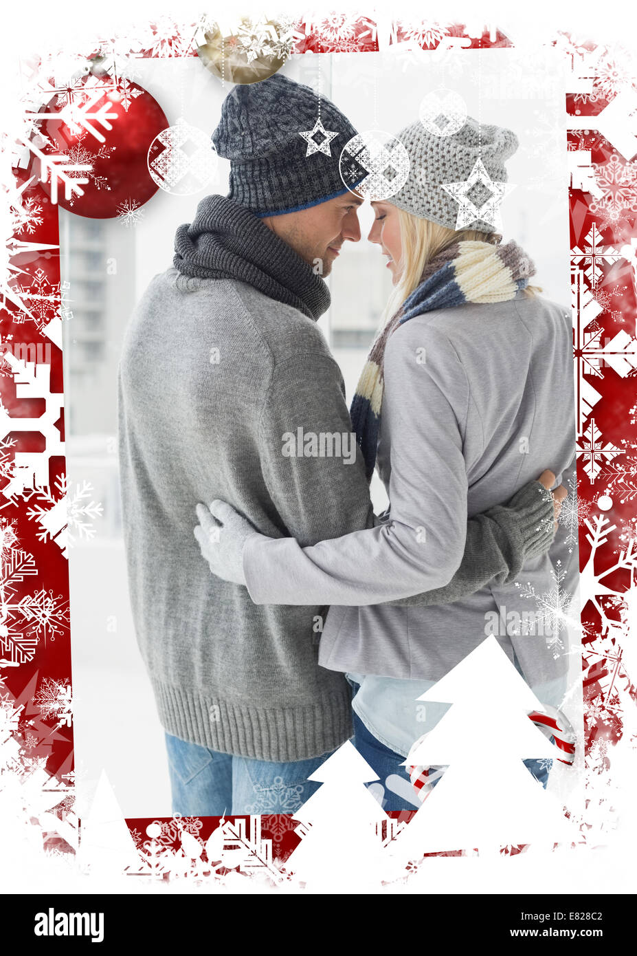 Composite image of cute couple in warm clothing hugging Stock Photo - Alamy