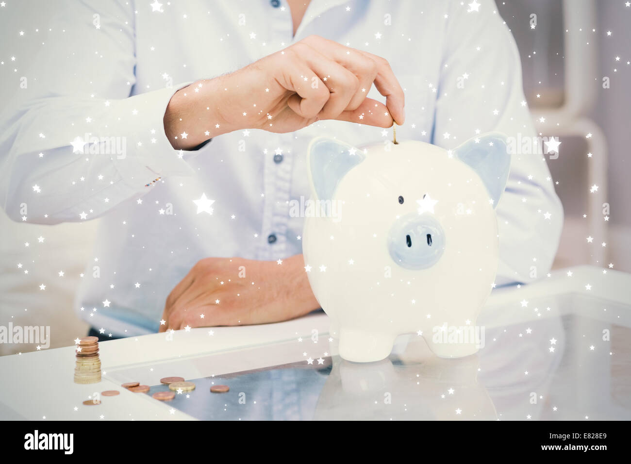 Mid section of a man putting some coins into a piggy bank Stock Photo ...
