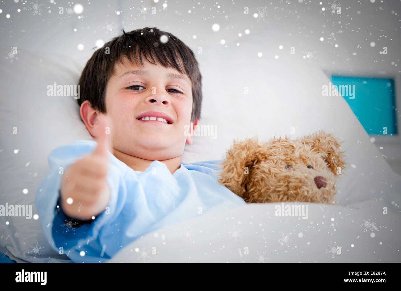Composite image of little boy hugging a teddy bear lying in a hospital ...