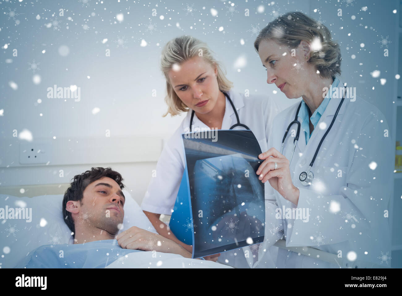 Composite image of doctors showing radiography to a patient Stock Photo
