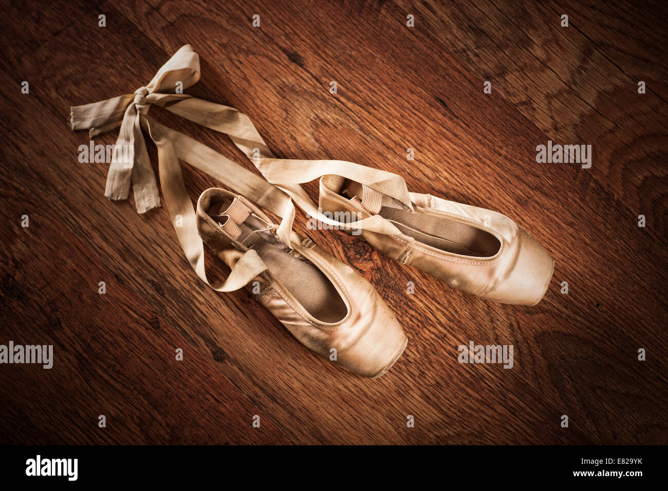 Pair of worn out ballet shoes on a wooden floor Stock Photo - Alamy