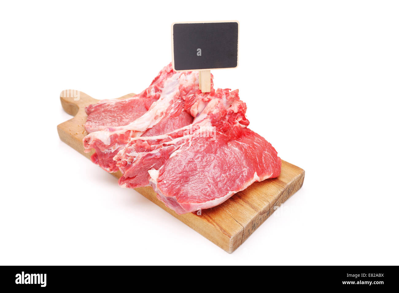 Studio shot of raw beefsteaks on a cutting board with a price tag isolated on white background Stock Photo