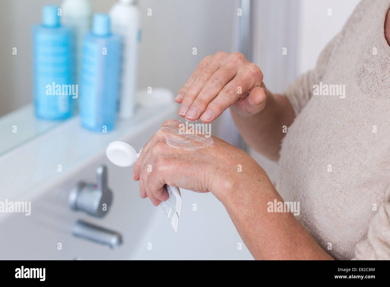 Woman applying moisturizing cream on her hands. Stock Photo