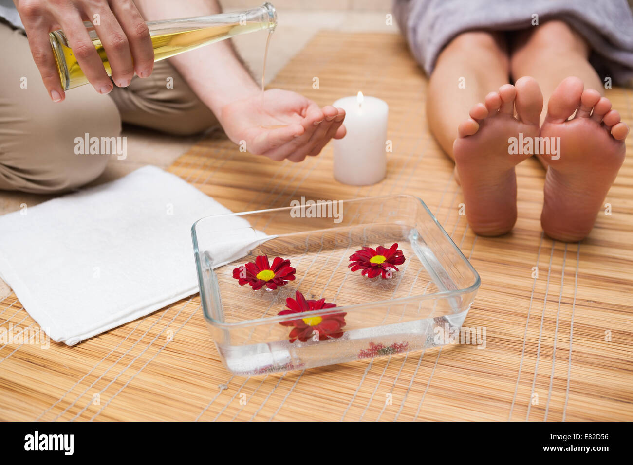 Pedicurist pouring oil into hands Stock Photo