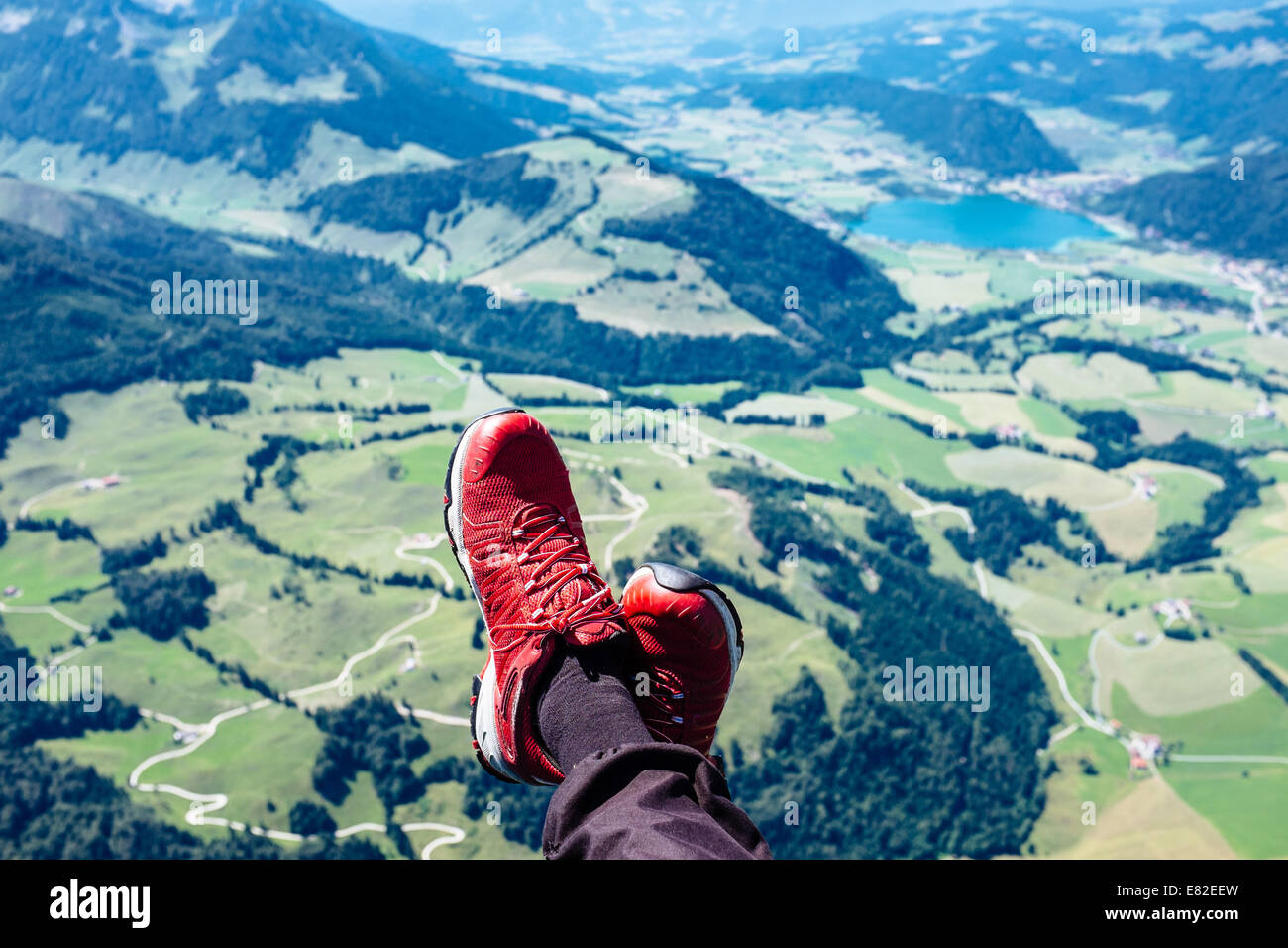 Feet of a paraglider pilot flying over Walchsee, Kaiserwinkl, Tirol , Austria Stock Photo