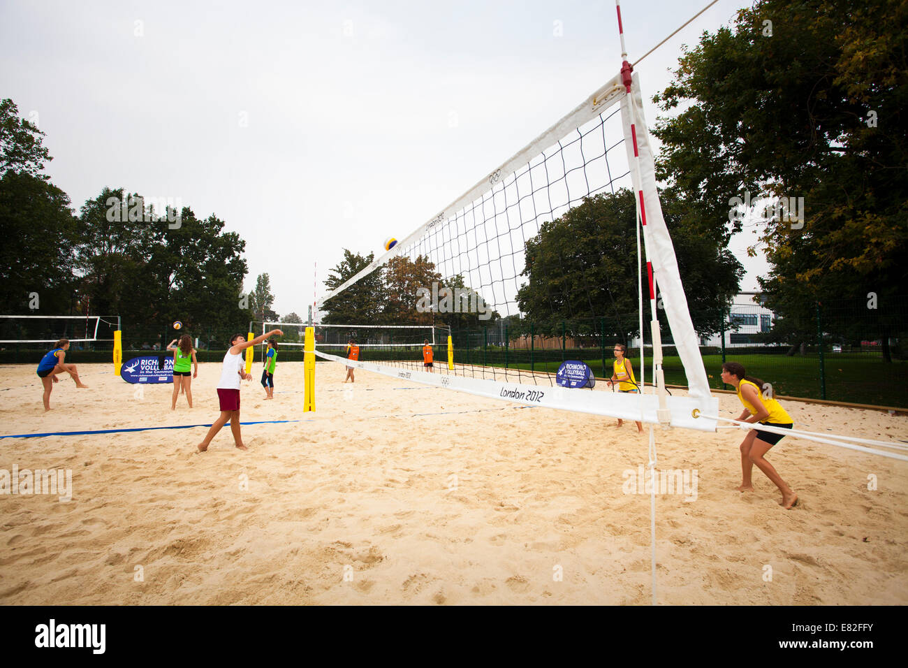 Young people playing on beach volleyball court in a park Stock Photo - Alamy