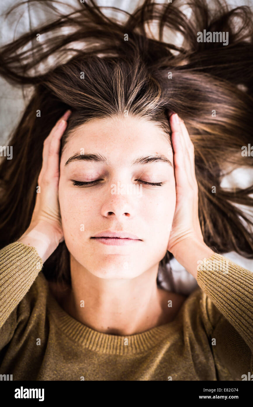 Senior woman holds her hands to her painful ears. Stock Photo