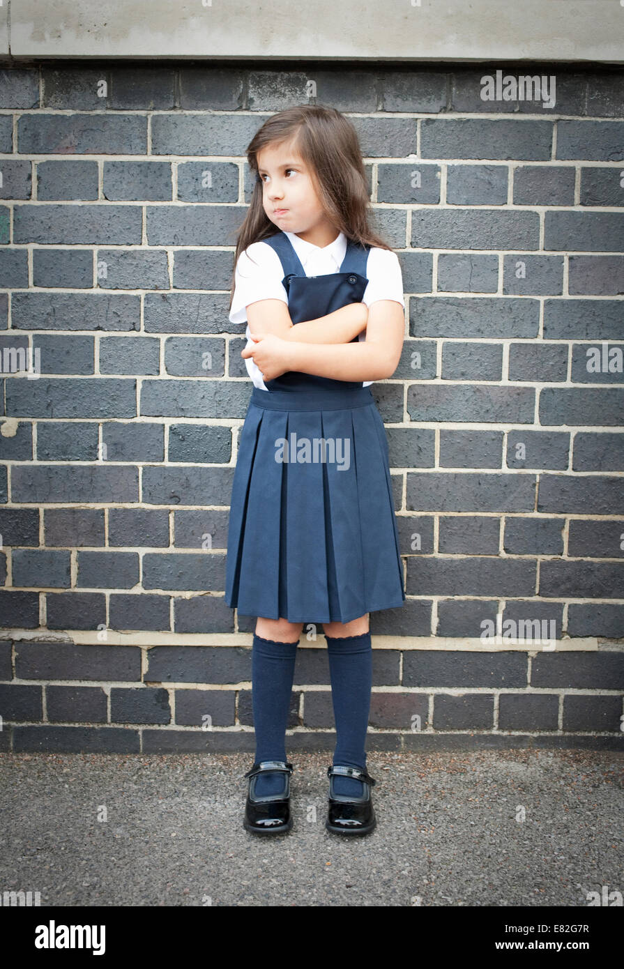 Portrait of girl in playground looking grumpy with arms folded Stock Photo