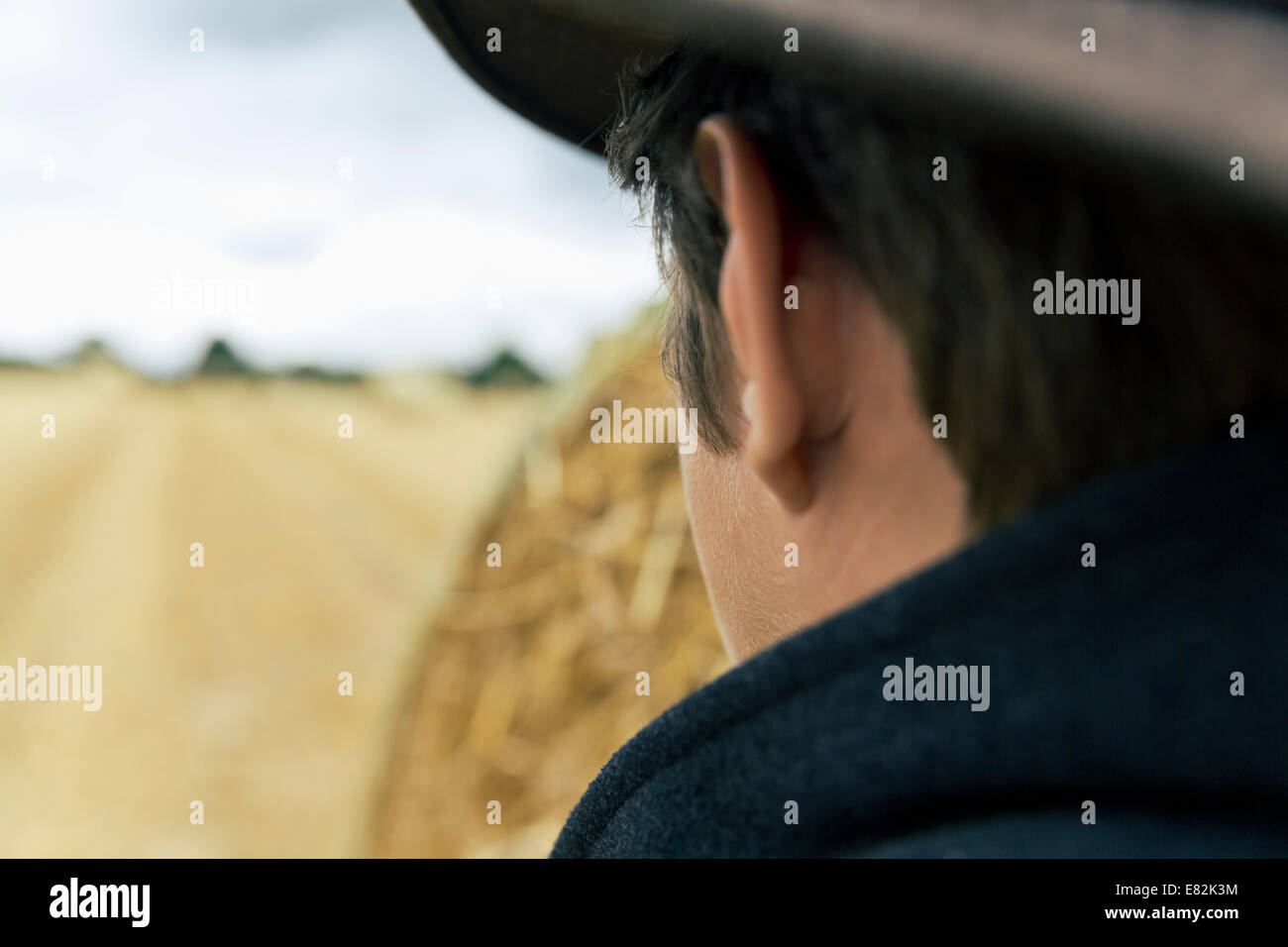 Teenage boy with hat looking to a grainfield Stock Photo
