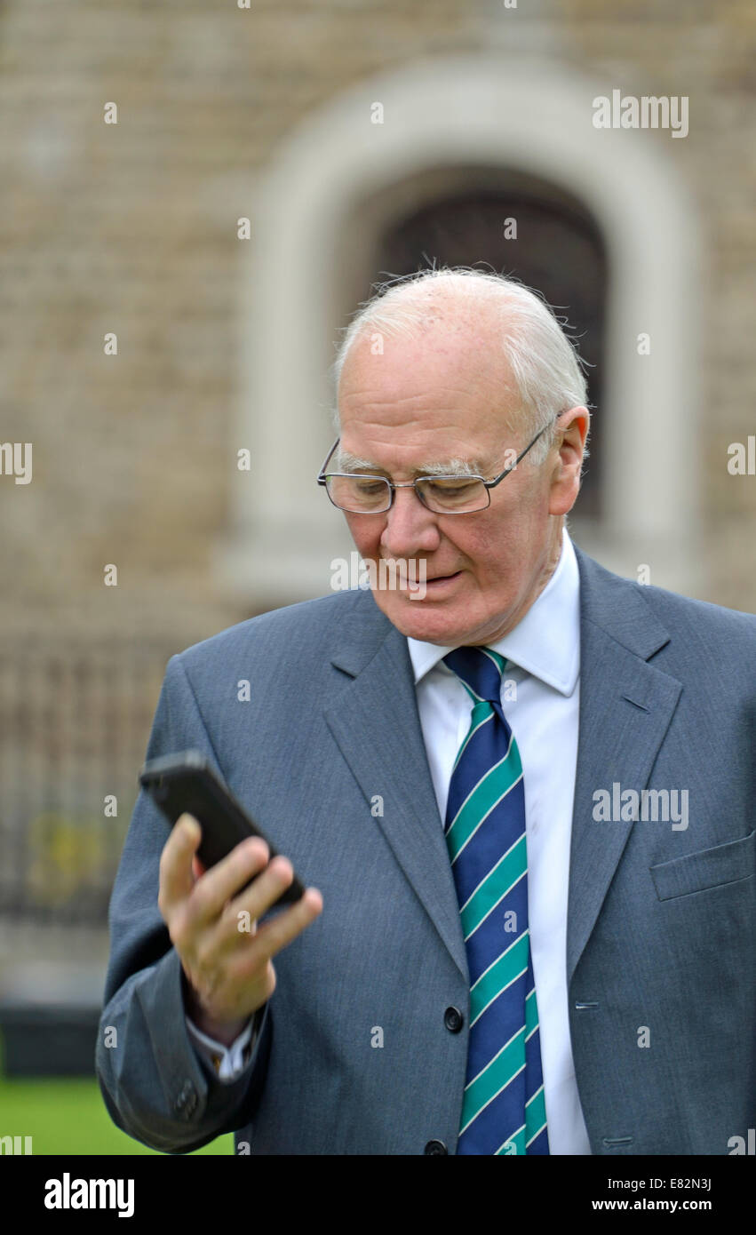 Sir Menzies (Ming) Campbell (Lib Dem) on his phone outside parliament during a debate going on in Parliament Stock Photo