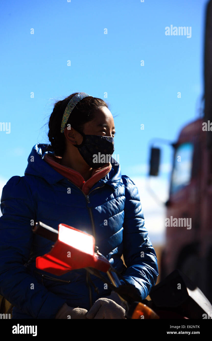 (140929) -- XINING, Sept. 29, 2014 (Xinhua) -- Photo taken on Sept. 21, 2014 shows Sonam Qoigyi watching the Qinghai-Tibet highway in southwest China's Tibet Autonomous Region. Sonam Qoigyi, 28, accompanies her fellow-villagers on a journey of pilgrimage to Lhasa. The year of 2014 marks the 60th anniversary of the opening of the Qinghai-Tibet highway. The highway, linking Xining, capital city of Qinghai province, and Lhasa, capital of the Tibet Autonomous Region, is a lifeline for Qinghai-Tibet Plateau. It boosts economic growth of regions along the road and makes lots of people's dreams come Stock Photo