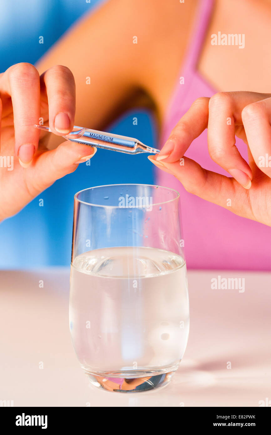 Woman holding glass ampoules of trace elements. Stock Photo