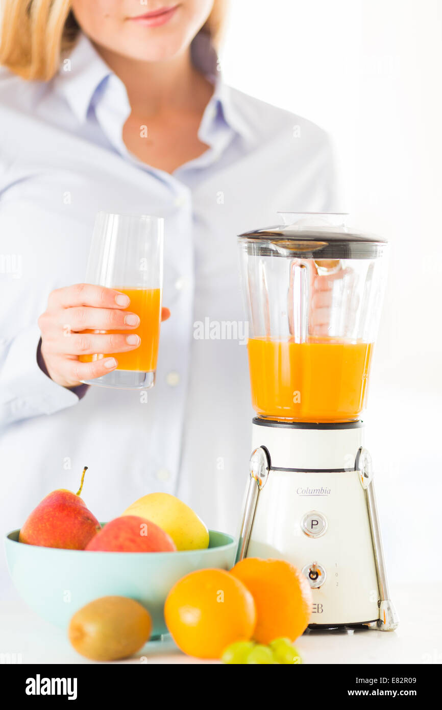 Woman making fruit juice in blender. Stock Photo
