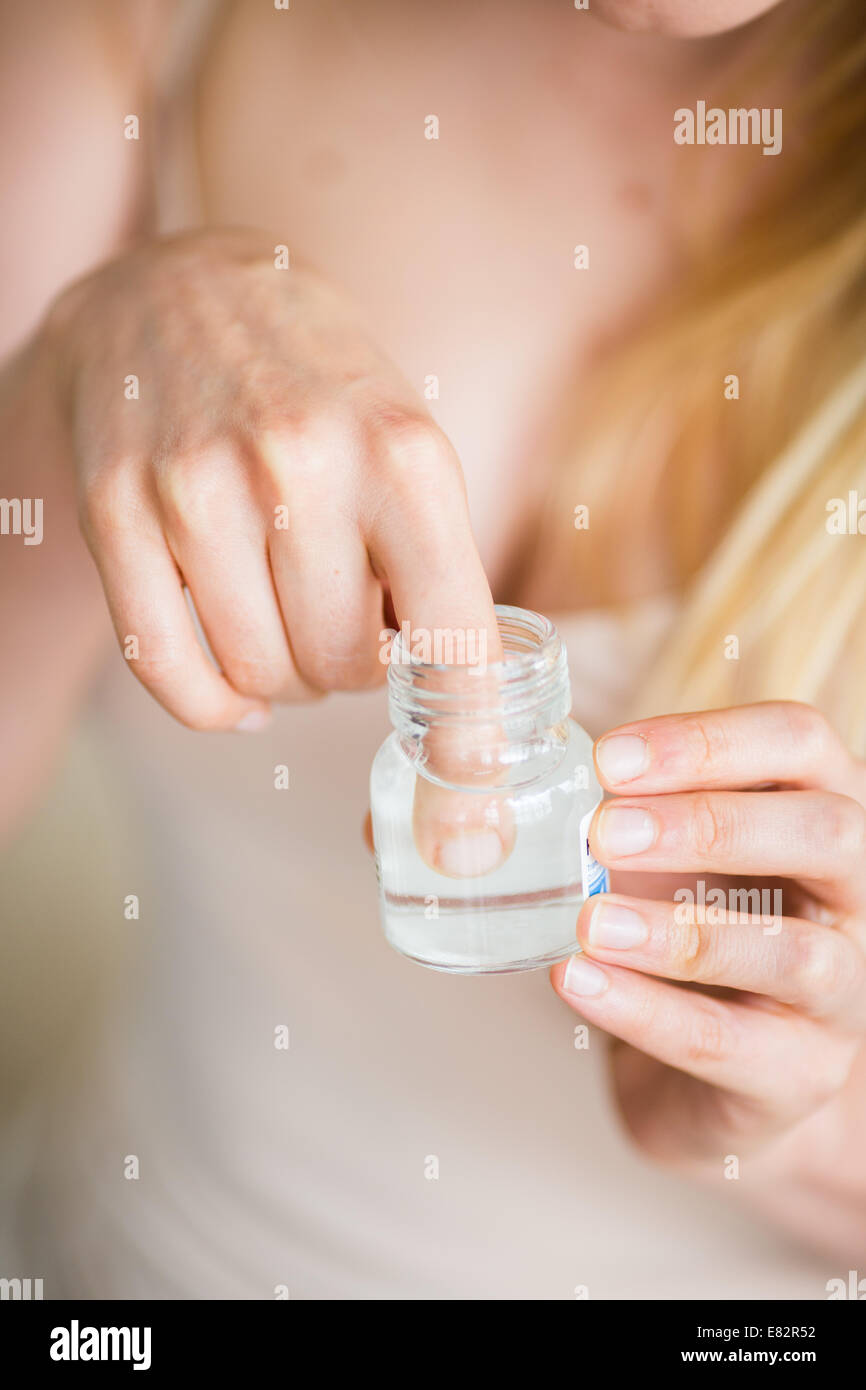 Woman disinfecting her finger with antiseptic. Stock Photo