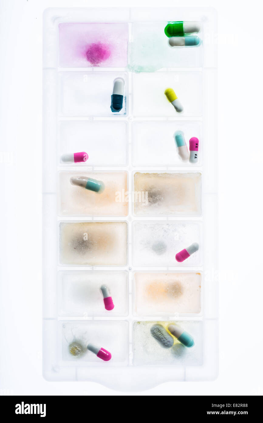 Capsules frozen in a block of ice. Stock Photo