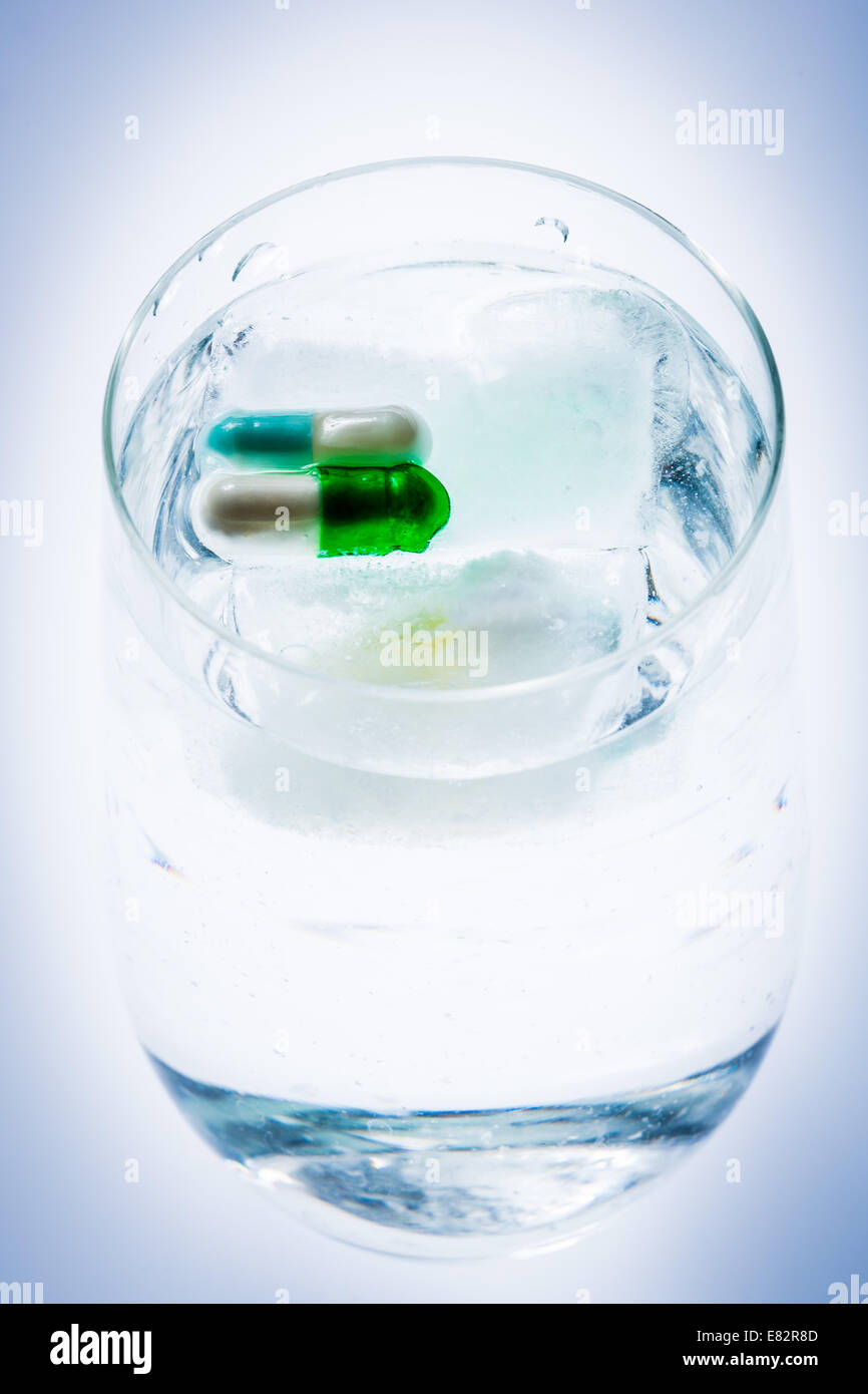 Capsules frozen in a block of ice. Stock Photo