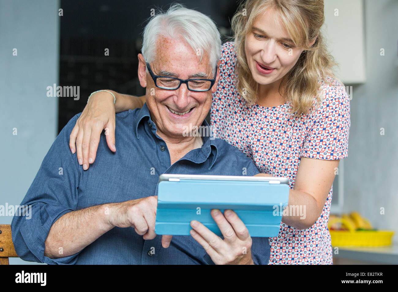 Woman helping senior to use a digital tablet. Stock Photo