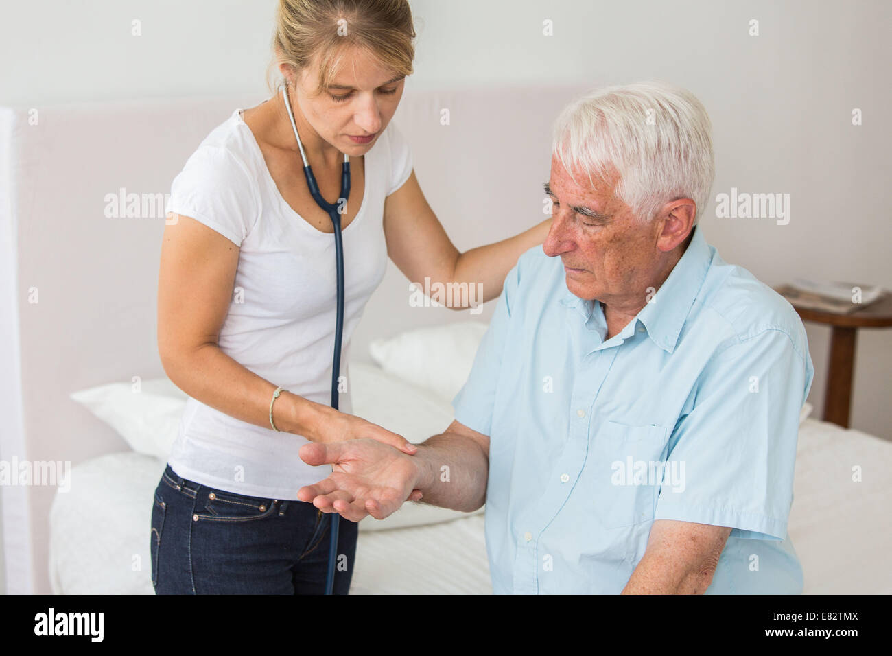 Doctor checking the pulse of an elderly patient. Stock Photo