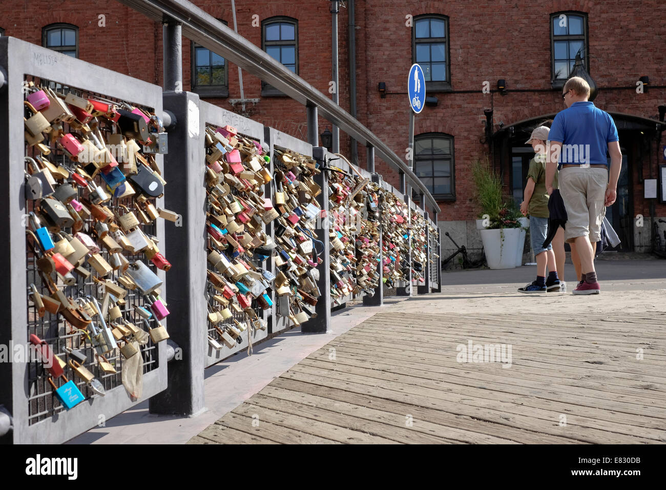 Finland, Helsinki, Rakkauden Silta, A man and a boy look at padlocks on the Bridge of Love located near the Linnanallas basin Stock Photo