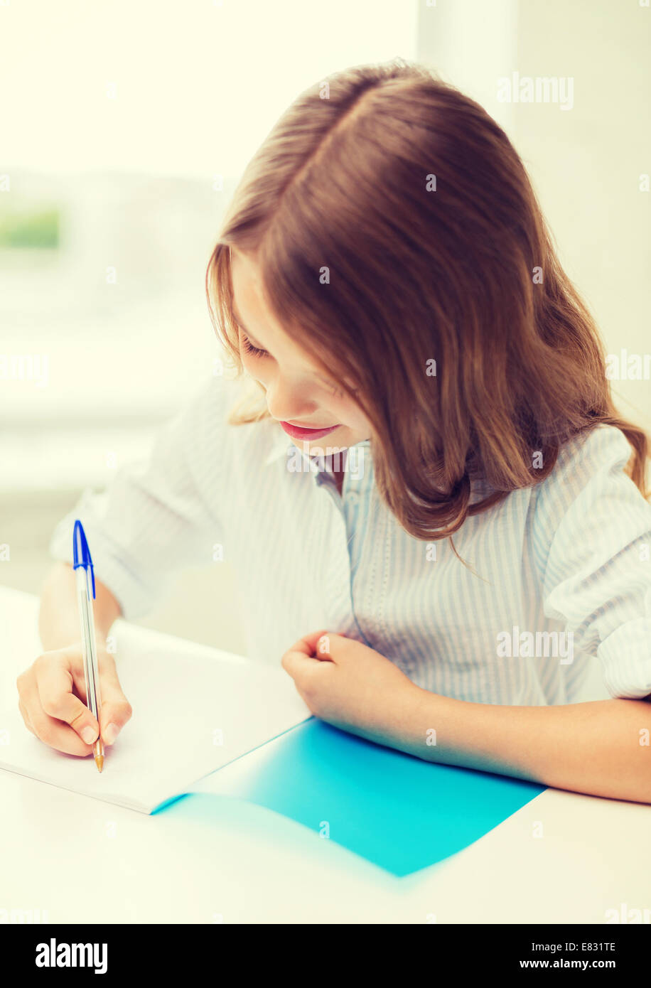 student girl writing in notebook at school Stock Photo - Alamy