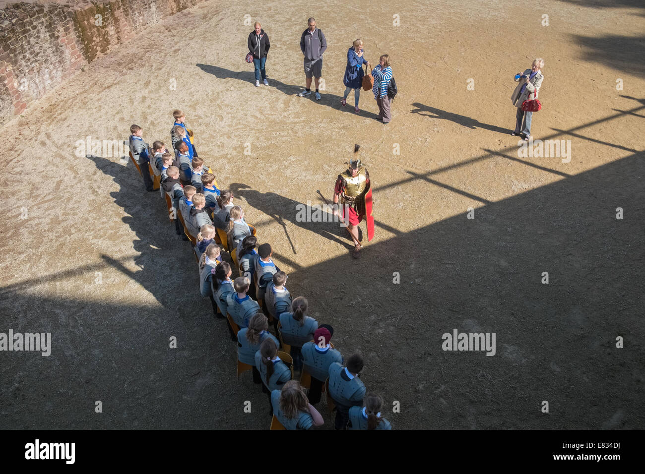 Primary school children having a roman history lesson at the Roman Ampitheatre, Chester, Cheshire, England UK Stock Photo