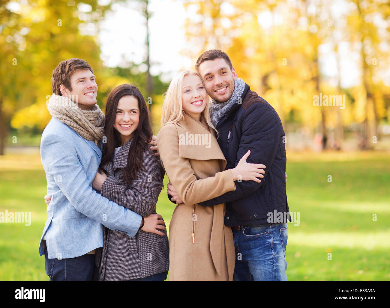 group of smiling men and women in autumn park Stock Photo