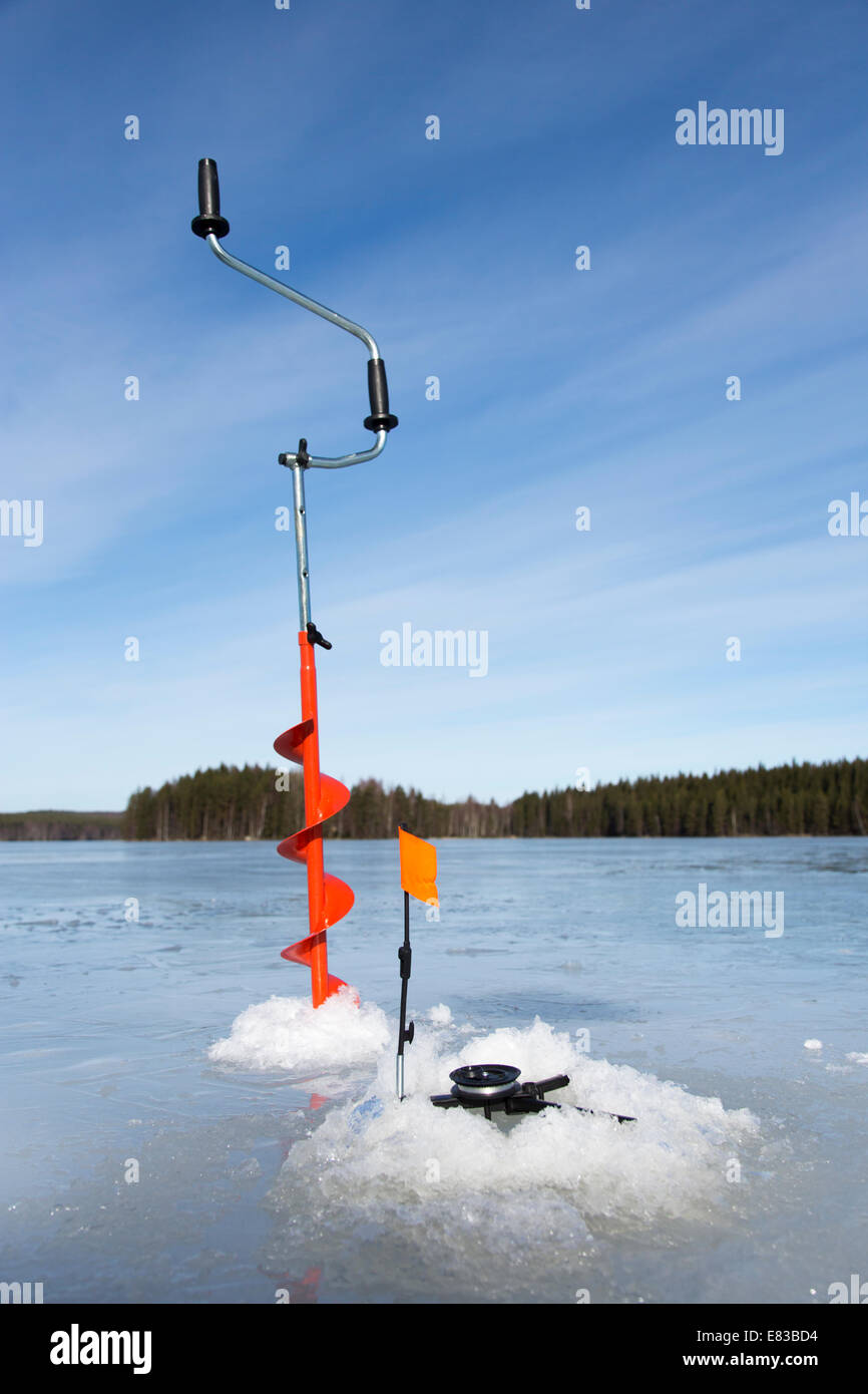 https://c8.alamy.com/comp/E83BD4/hand-ice-auger-and-tip-up-ice-fishing-rod-at-frozen-lake-at-winter-E83BD4.jpg