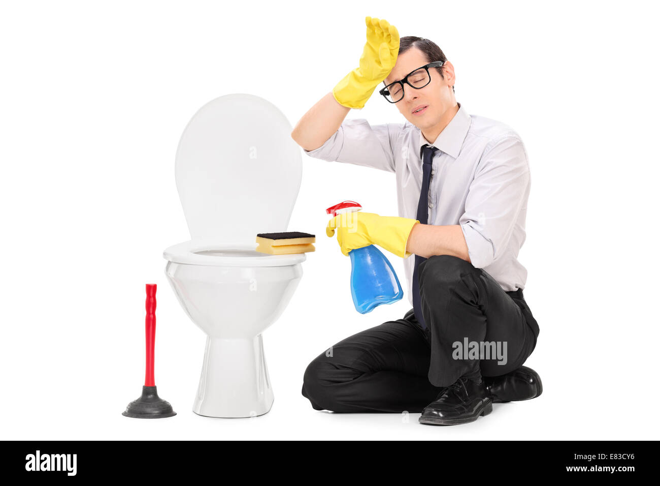 Exhausted young man cleaning a toilet isolated on white background Stock Photo