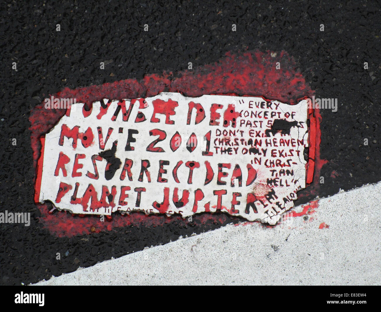 A Toynbee Tile is seen embedded into the pavement at a site in the Chelsea neighborhood of New York Stock Photo
