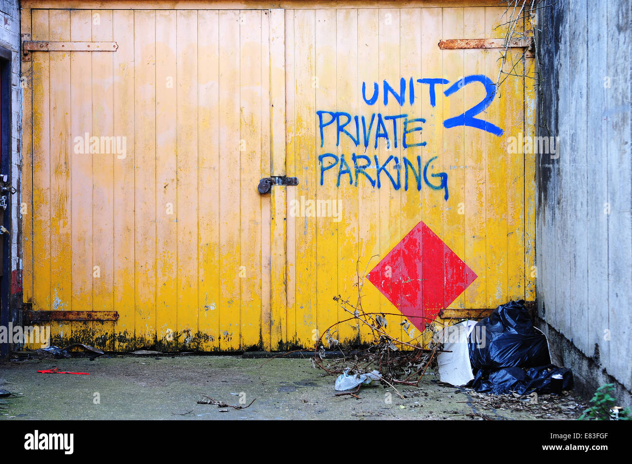 Grotty bright yellow Garage doors with rubbish Stock Photo Alamy