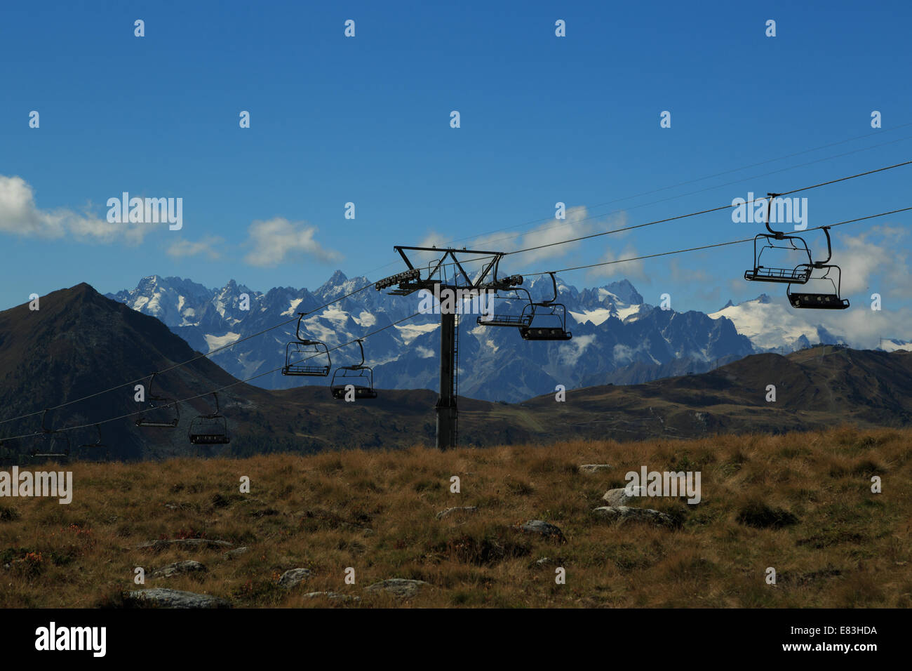 A landscape photograph of an empty ski lift in the swiss alps in Autumn. The photograph was taken at the start of autumn. Stock Photo