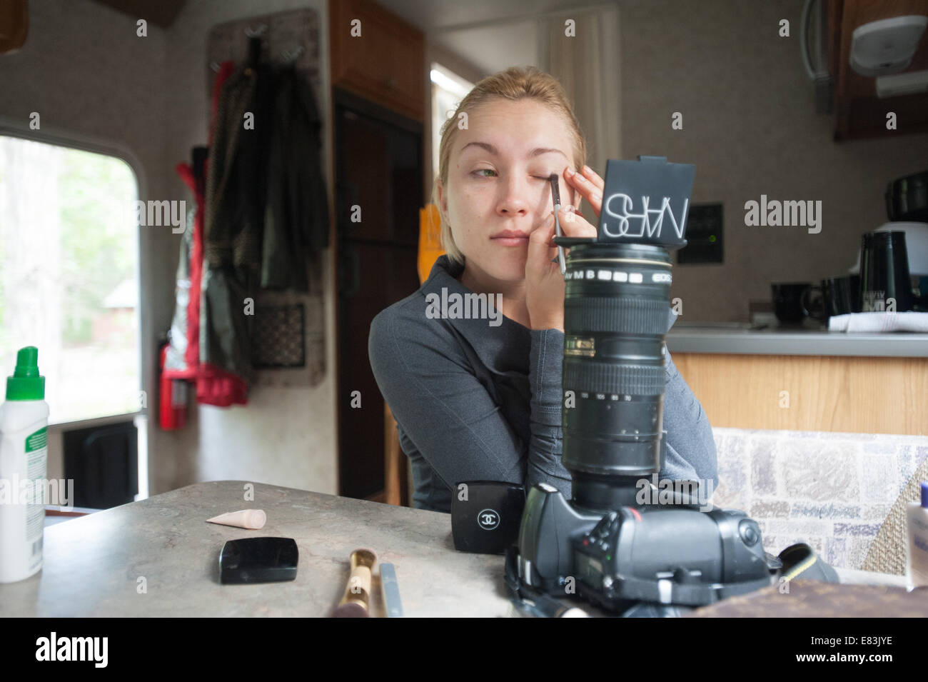 Model applies makeup in RV using camera as mirror stand Stock Photo Alamy