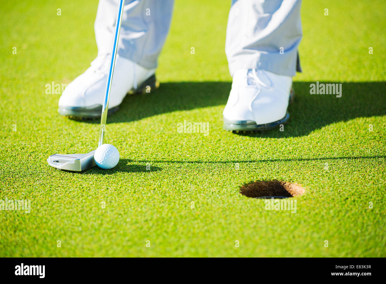 Man Putting Golf Ball into the Hole, Close up detail Shot Stock Photo