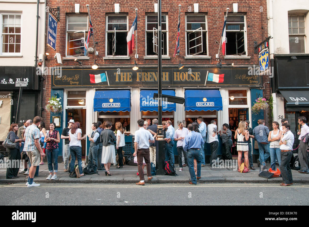 People drinking outside The French House pub, Soho, London, England, UK
