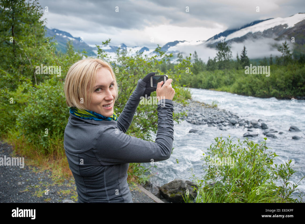 Woman using iPhone smartphone in Alaska Stock Photo