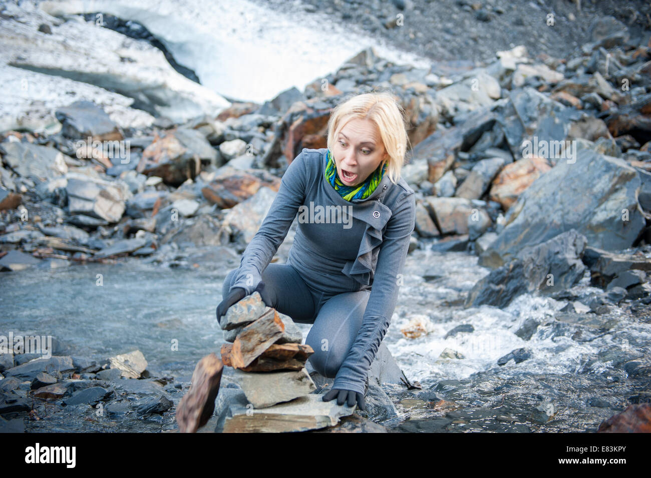 Woman react to falling cairn in Alaska Stock Photo