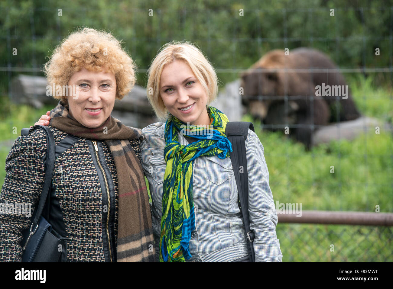 Mother and daughter together in front of bear in Alaska Stock Photo