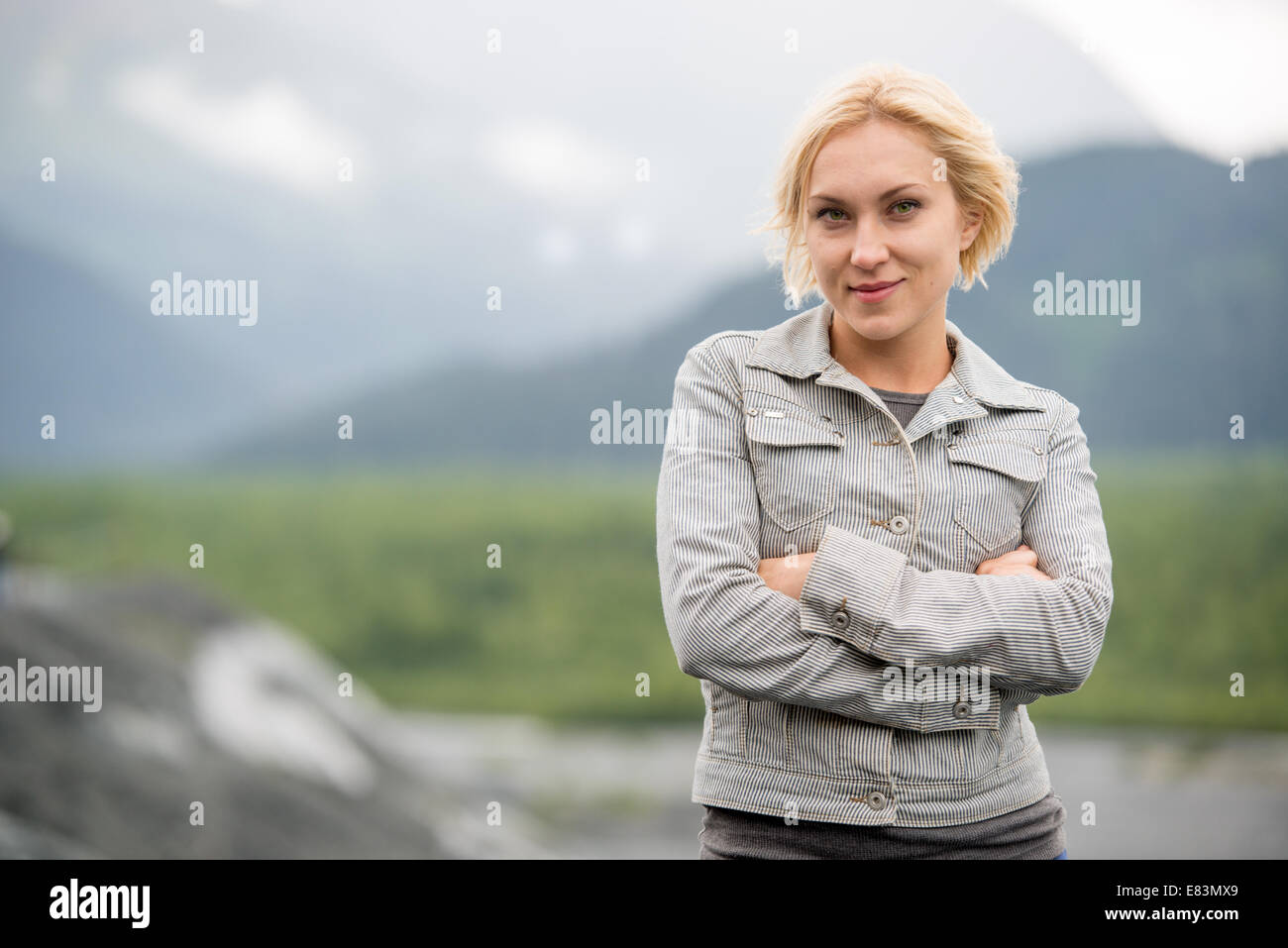Blonde woman in front of mountains near Seward  Alaska Stock Photo