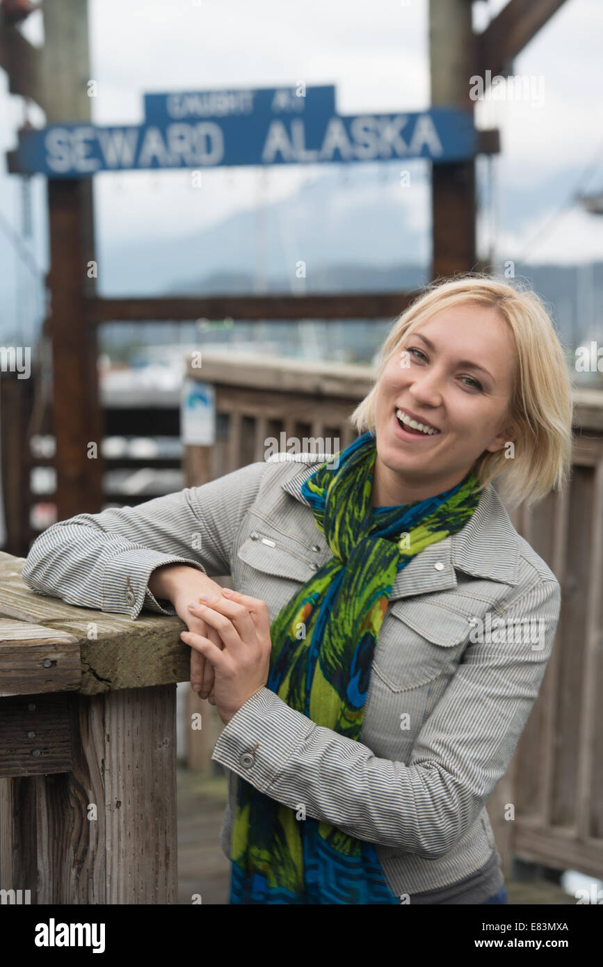 Blonde woman in front of marina in Seward  Alaska Stock Photo