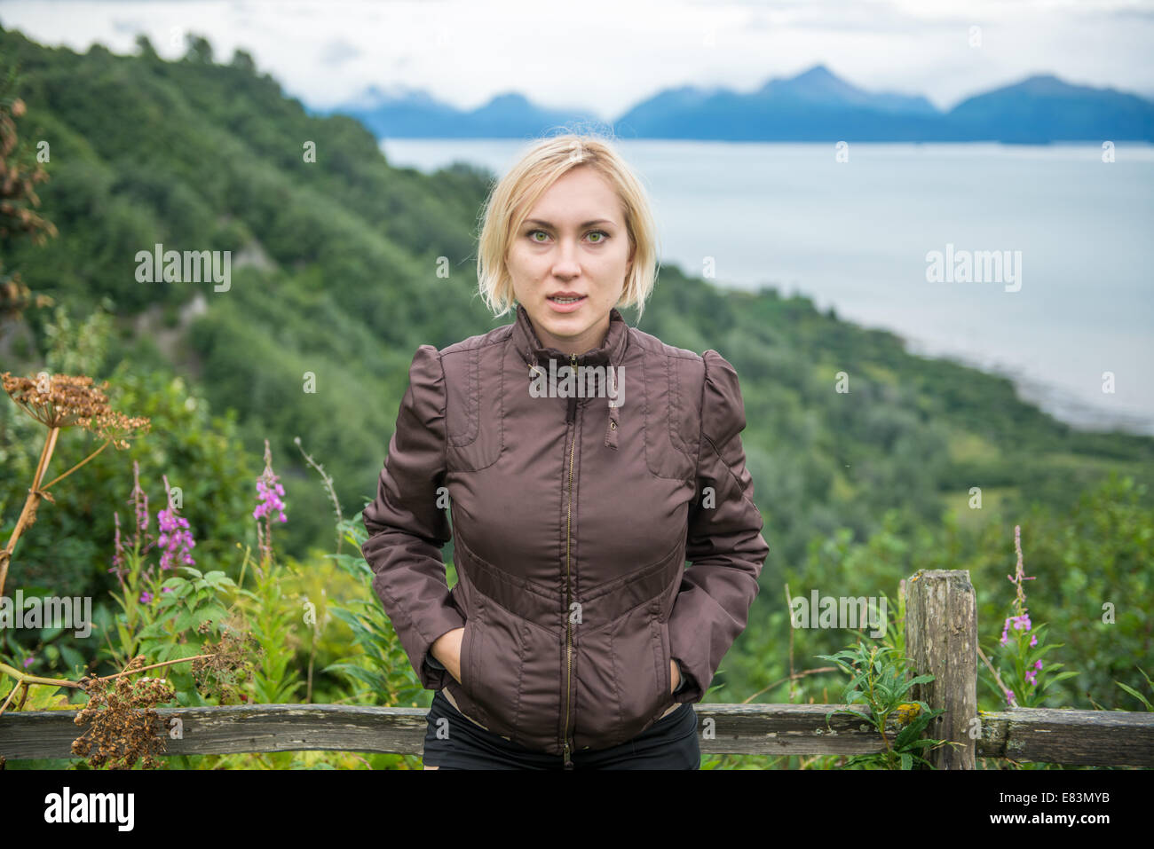 Blonde woman in front of mountains near Homer Alaska Stock Photo