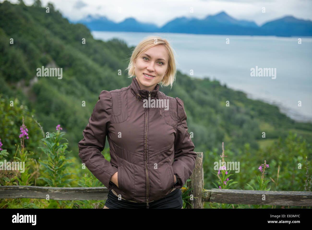 Blonde woman in front of mountains near Homer Alaska Stock Photo
