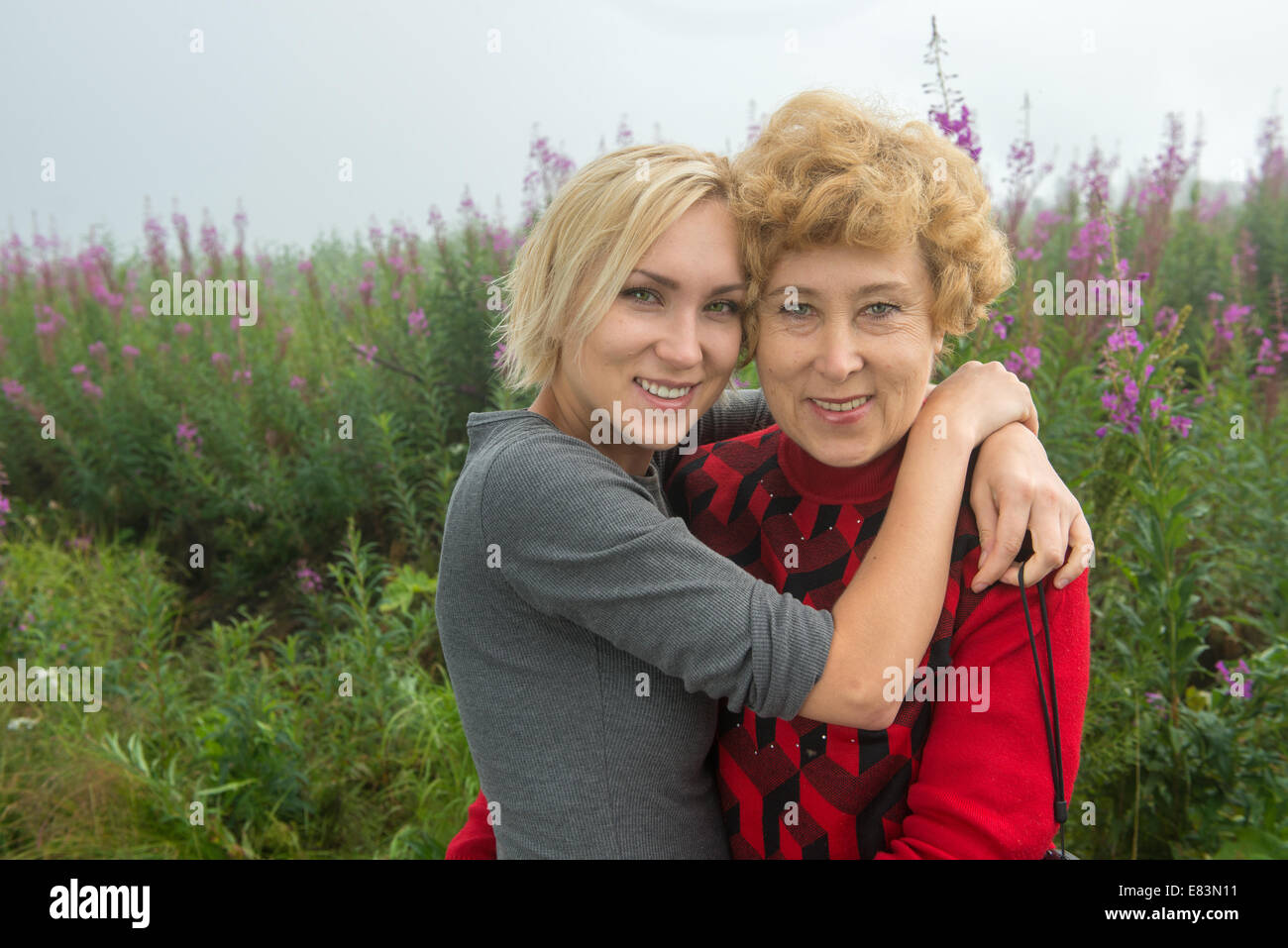 Mother and daughter together in from of fireweed in Alaska Stock Photo