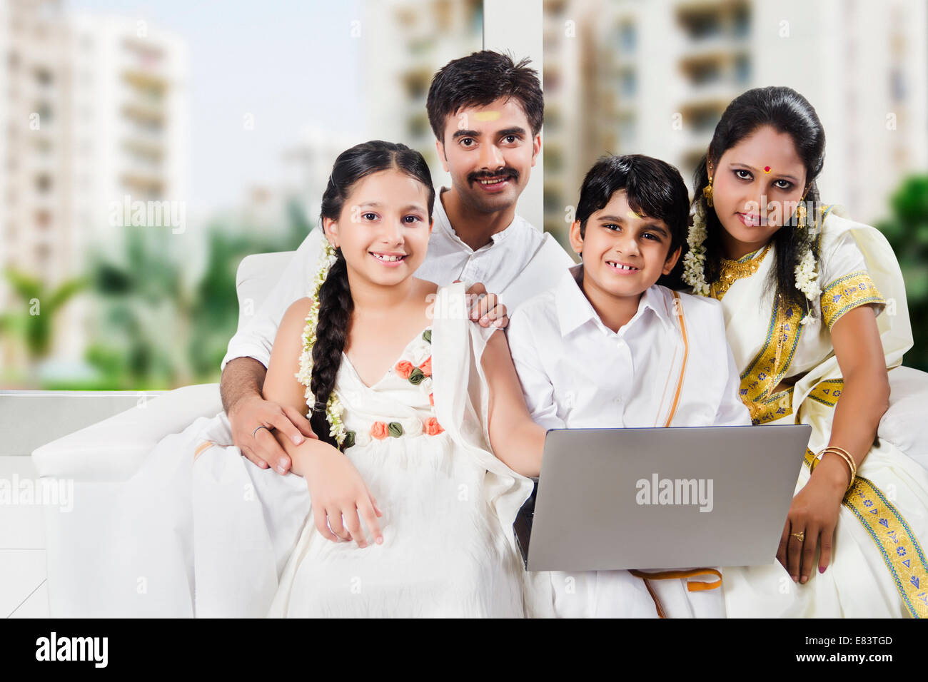 South Indian family sitting home with laptop Stock Photo