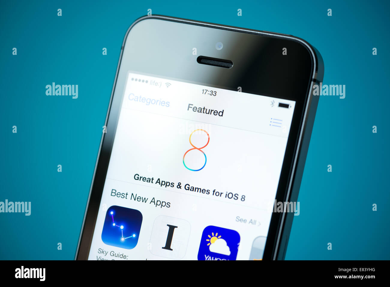Close-up shot of brand new Apple iPhone 5S showing App Store with iOS8 featured games and application for download. Stock Photo