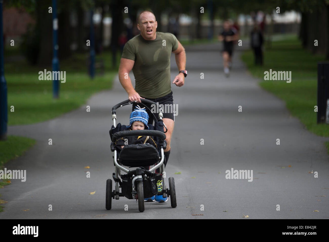 A man pushing a buggy taking part in the global weekly 5k Adidas-sponsored  'ParkRun' in Plascrug avenue, Aberystwyth Wales UK Stock Photo - Alamy