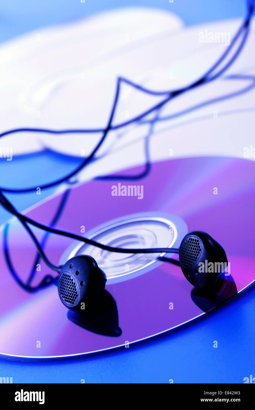 compact disk with earphone, on blue lighting Stock Photo