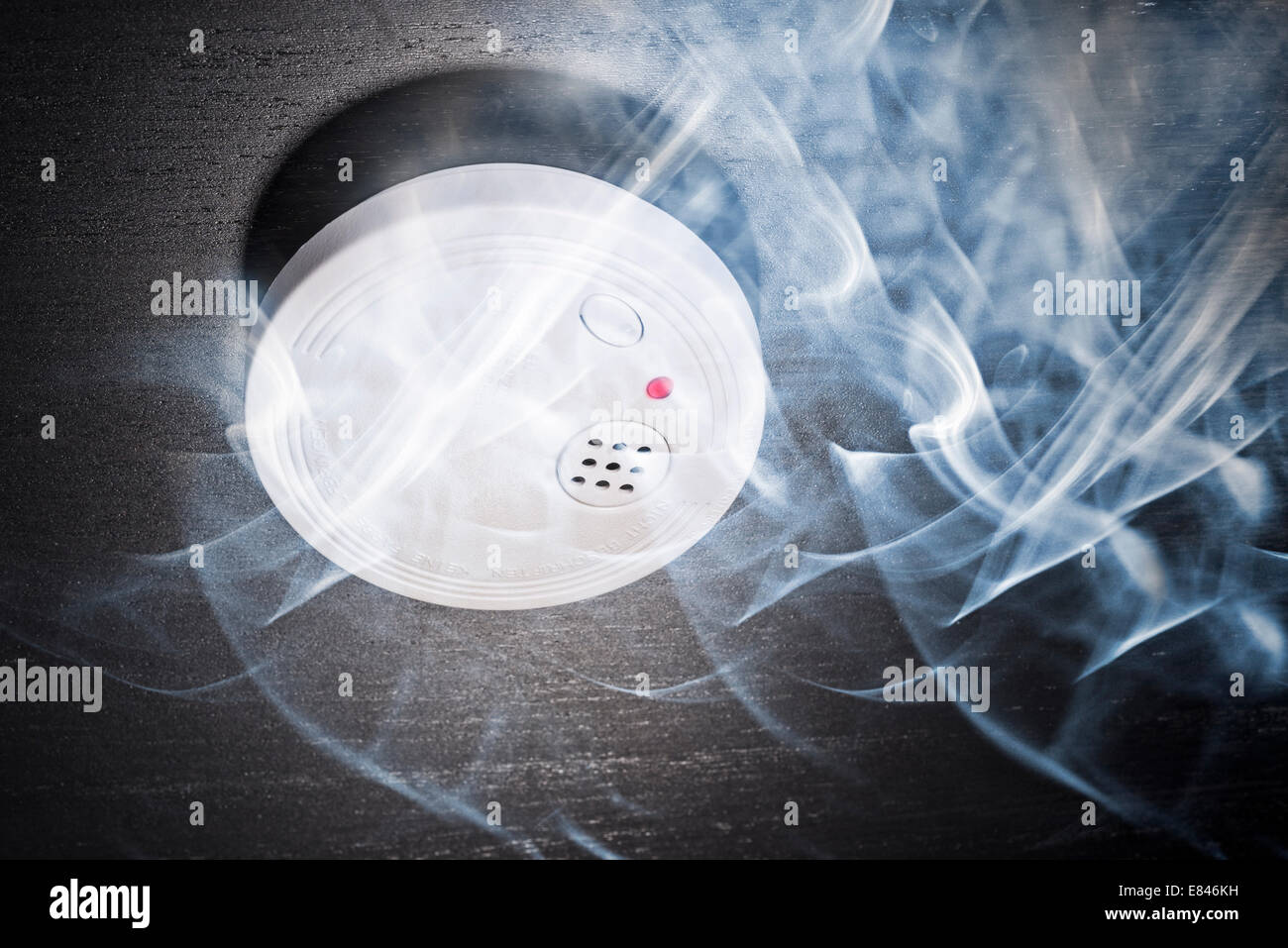 Smoke detector in the smoke of a fire. Stock Photo